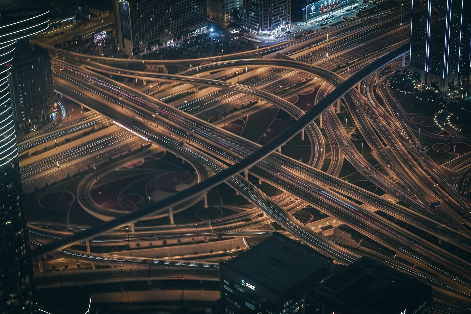 A large highway interchange at night, lit by traffic